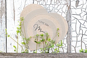 I love You Mum written on heart-shaped greeting card on a rustic old wall