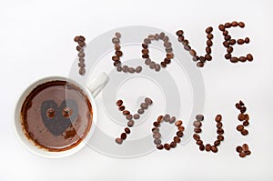 I love you sign with coffee beans and cup of coffee over white b