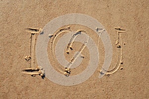 I love you sign whiten on the sand at the beach. Romantic love symbol at tropical seashore at sunset