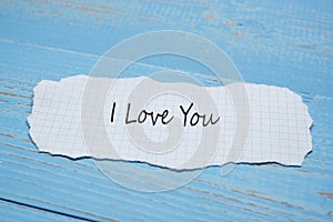 I LOVE YOU word on paper note on blue wooden table background. Wedding, Romantic and Happy Valentineâ€™ s day holiday concept