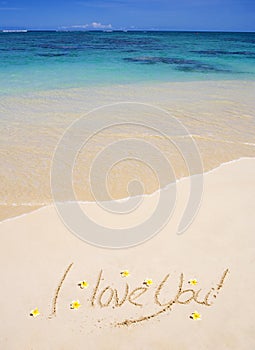 I love you written on a sandy beach