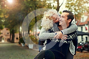 I love you. a young woman kissing her husband while walking through a foreign city.