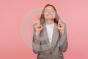 I am lucky, dreams come true! Portrait of optimistic young woman in business suit making wish