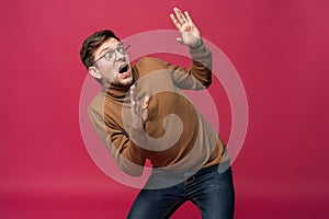 I`m afraid. Fright. Portrait of the scared man on trendy pink studio background. Male half-length portrait