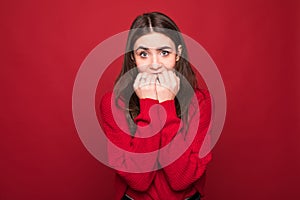 I`m afraid. Fright. Portrait of the scared woman. Young woman standing isolated on trendy red studio background. Female half-