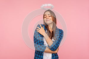 I`m the best! Self-love concept. Portrait of attractive girl in casual shirt and with nimbus over head