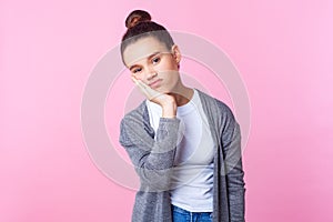 I`m bored. Portrait of depressed brunette teenage girl leaning on head, looking tedious tired of everything. pink background