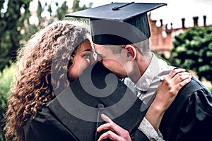 I`m glad that we could share this milestone together. Couple graduates are standing near university and kiss each other