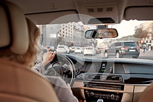 I`m in love with my car. Reflection of woman in the rear-view mirror of the car. Business woman driving a car