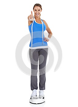 I made it, and so can you - Weight loss goals. Fit young woman giving you a thumbs up against a white background while
