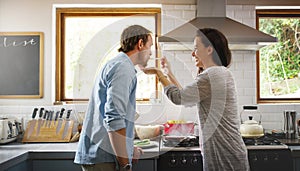 I made it just how you like it. an affectionate young woman feeding her husband a spoonful of her food while cooking in