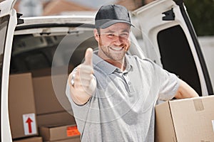 I always make my deliveries on time. Cropped portrait of a handsome young delivery man giving thumbs up while out making