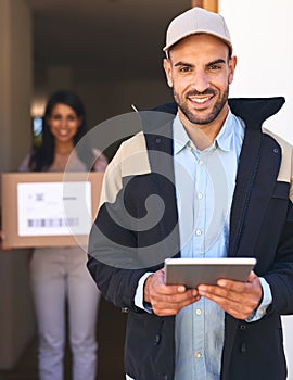 I manage everything on this little device. Portrait of a courier using a digital tablet while making a delivery to a