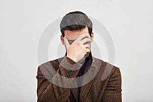 I messed up. Young man covering his eyes with hand in shame isolated on a white background