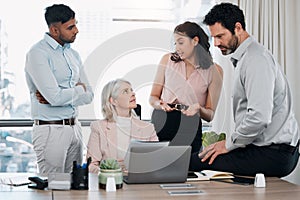 I might have an idea. a diverse group of businesspeople using a laptop during a meeting in the office.