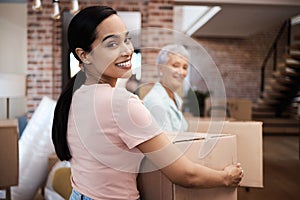 I might leave but the memories will live on forever. a young woman helping her elderly mother move house.