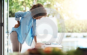 I might need a massage, this is starting to hurt. Shot of a young woman experiencing back pain while working on her