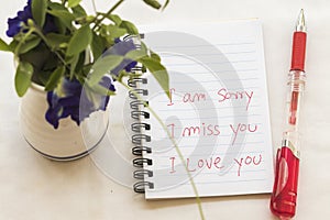 I miss you i am sorry i love you message card write on notebook with flowers