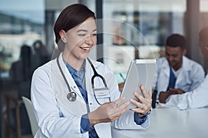 I miss you so much. a young female doctor taking a break to use her digital tablet.