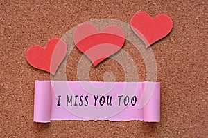 I miss you too label on Torn paper with heart shape on wooden background