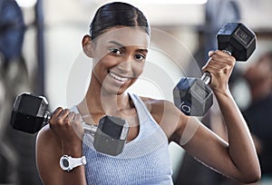 I moved on to heavier weights. Portrait of a sporty young woman exercising with dumbbells in a gym.