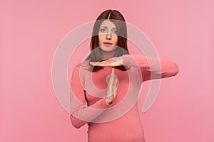 I need break! Tired upset brunette woman in pink sweater showing time out gesture, stop or limit hand sign, deadline