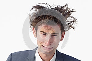 I need help. A young businessman with messy hair whimpering while isolated on white.