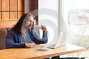 I need more. Portrait of handsome intelligence young adult man freelancer in casual style sitting in cafe and looking at laptop