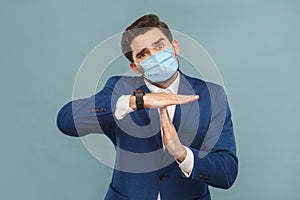 I need more time. Please, need time out. Body language. Portrait of pleading man with surgical medical mask and showing timeout