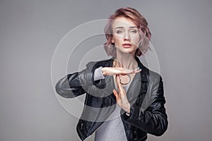 I need more time please. Portrait of beautiful girl with short hairstyle and makeup in casual style black leather jacket standing