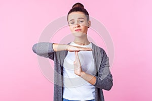 I need more time! Portrait of cute brunette teenage girl showing time out gesture. studio shot isolated on pink background