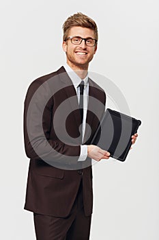 I never leave the office without it. Studio portrait of a stylishly-dressed young businessman holding a digital tablet.