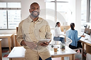 I never miss a business opportunity. a mature businessman using a digital tablet in a modern office.