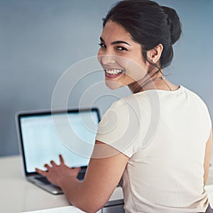 I never miss a deadline. Cropped portrait of an attractive young businesswoman working on a laptop in her office.