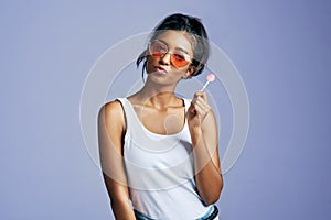 I never pout...unnecessarily. Studio portrait of a beautiful young woman sucking on a lollipop against a purple photo