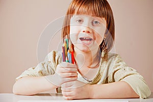 I paint the world with colored pencils. Humorous photo of great artist. Portrait of cute little child girl with colored pencils