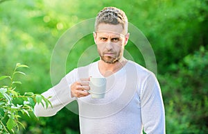 I prefer green tea. Refreshing drink. Man bearded tea farmer hold mug nature background. Green tea contains bioactive photo