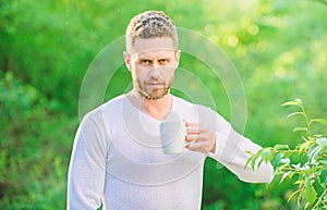 I prefer green tea. Refreshing drink. Man bearded tea farmer hold mug nature background. Green tea contains bioactive photo