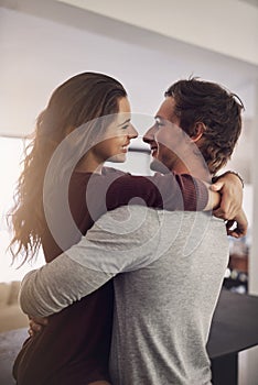 I promise to love you forever. an affectionate young couple hugging in the kitchen at home.