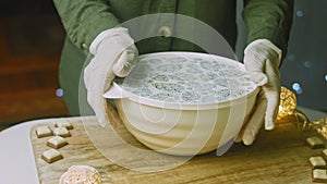 I put a lid on and mix the ingredients for the countertop. Christmas atmosphere with lights in the background