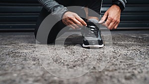 I am ready. an unrecognizable woman crouched down and tying her shoes before running outside.