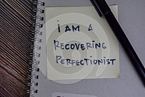 I am A Recovering Perfectionist write on sticky notes isolated on Wooden Table