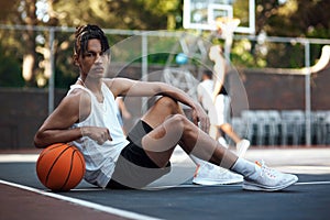 I refuse to lose. Portrait of a sporty young man sitting on a basketball court.