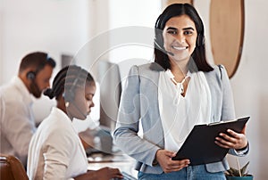 I see to it that my team are always on top. Portrait of a young call centre agent holding a folder in an office with her