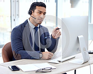 I see what the issue is. a customer service agent wearing a headset while sitting at his desk.