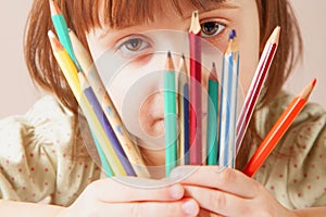 I see the world colored! Humorous photo of great artist. Portrait of cute little child girl with colored pencils