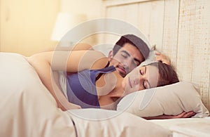 I sleep better when Im next to you. Shot of a loving young couple sleeping in bed together.
