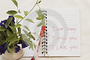 I am sorry i miss you i love you message card write on notebook with flowers