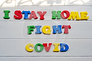 I Stay home fight covid-19  Sign & Symbol, plastic letter on white wood background
