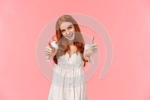 I support your choice. Charismatic excited, happy redhead woman in white dress, showing thumbs-up to cheer you, agree or